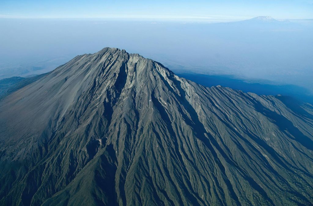 Arusha City Guide – aerial view of Arusha National Park with Mount Meru rising above lush forests and wildlife habitat in northern Tanzania