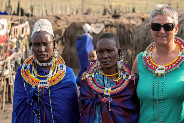Maasai culture in Tanzania Maasai people wearing traditional ornaments near Serengeti National Park interacting with tourists