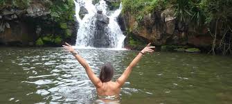 Female tourist swimming at Materuni Waterfalls pool, showcasing Materuni Waterfalls highlights in Tanzania