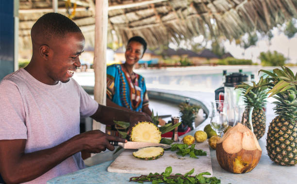 Zanzibar cultural insights African bartender preparing fresh fruit cocktail during Zanzibar spice tour experience